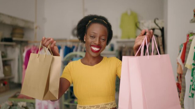 African american woman customer smiling confident holding shopping bags at clothing store