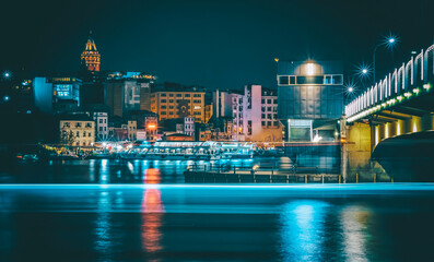 Golden horn halic bridge and boats and city scape galata tower and architecture with night lights 