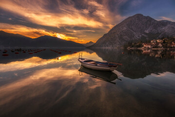 Kotor bay view with beautiful reflection of houses mountains and clouds with sunset sunrise colors