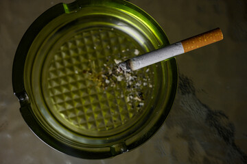 Lit cigarette burning in ashtray close up. High quality photo