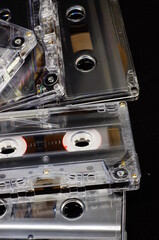 Cassette tapes - unprinted, scattered loosely on table, black background.