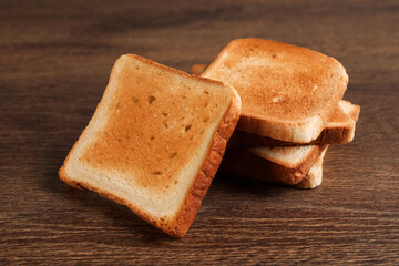 Slices of delicious toasted bread on wooden table