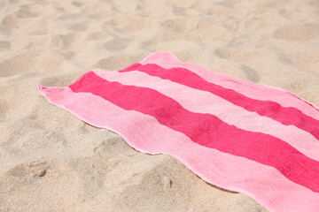 Soft pink striped towel on beach sand