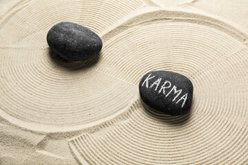 Fototapeta na wymiar Stones with word Karma on sand, above view
