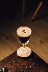 espresso martini cocktail in a fancy elegant glass with coffee beans in a table