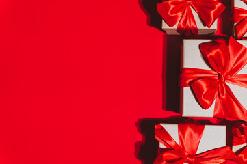 Gorgeous festive Christmas banner or header, holiday presents on red background. Christmas gift boxes on red. Holiday season, New Year. Copy space for text.