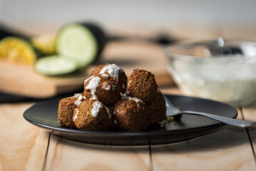 Falafel balls on blak plate with greek yogurt