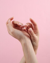 Beautiful female hands with manicure on a pink background. Beauty concept