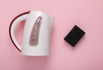 Electric kettle with a sponge on a pink background. Kettle cleaning, clean water concept