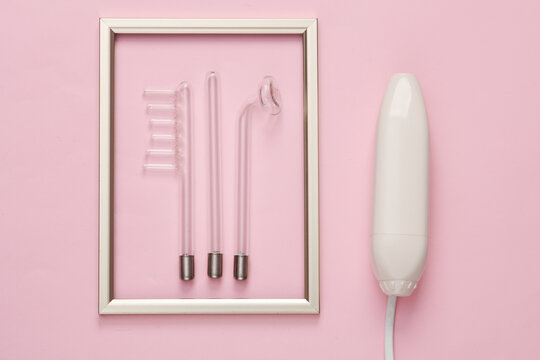 Device for local darsonvalization with frame on pink background. Treatment of acne, problem skin. Top view. Flat lay composition