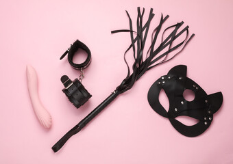 Sex games. Different toys from sex shop on pink background. Top view