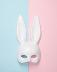 White rabbit mask with long ears from a sex shop on a blue-pink pastel background