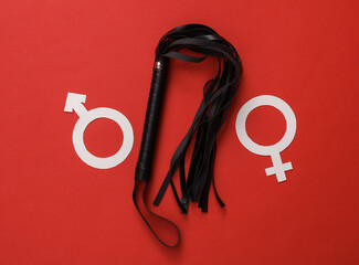 Leather sex shop whip with gender symbols on a red background. Domination
