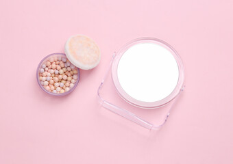 Obraz na płótnie Canvas Balls of powder with a mirror on a pink background. Makeup, beauty concept