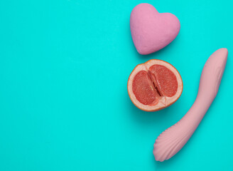 Obraz na płótnie Canvas Sex and fruit concept. Vibrator and half a grapefruit, vibrator on a pink background. Self satisfaction masturbation