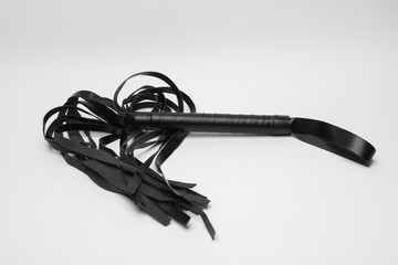 Leather whip from sex shop on white background. Sex games.