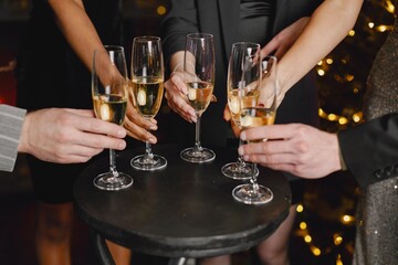 Midsection people holding a glasses with champagne while celebrating New Year