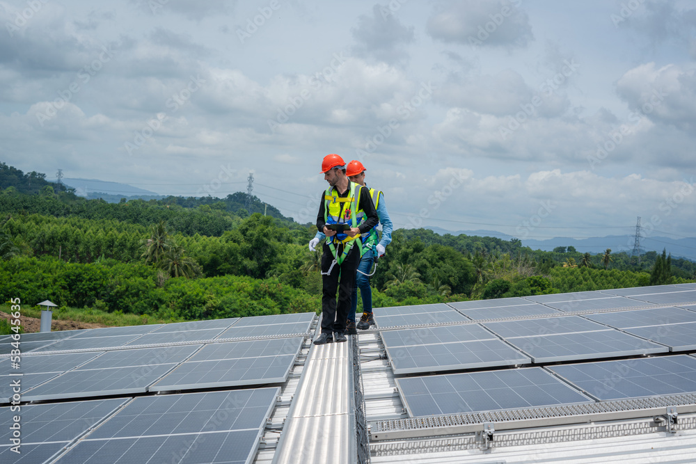Poster engineers checking the operation of the system solar cell on roof at factory,alternative energy to c