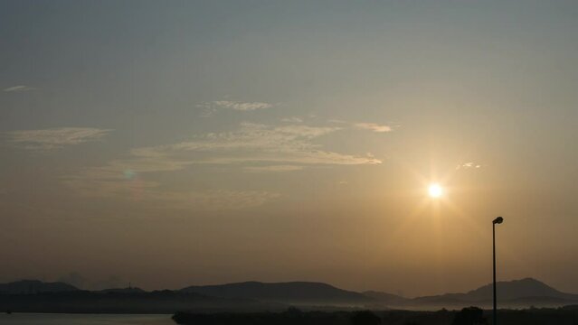 4K UHD timelapse of sunset on fishing community area . Sun rays, blue sky and bridge. Summer sunset time