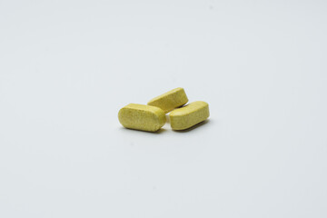 greenish yellow herbal tablets pill, traditional medicine, organic pills, isolated on a white background