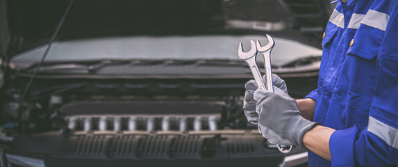 Car care maintenance and servicing, Close-up hand technician auto mechanic holding the wrench to...