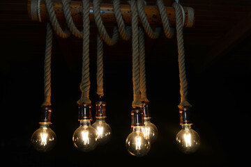 Incandescent hanging light bulbs. Light bulbs in lighting decoration with lamps in vintage tone and...