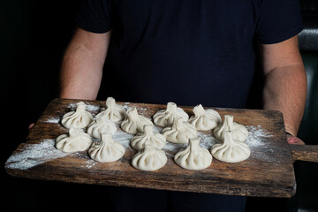 chef cooking khinkali and pinching the dough