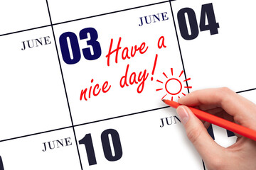 The hand writing the text Have a nice day and drawing the sun on the calendar date June 3