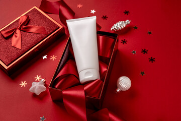 White bottle cosmetic product in red giftbox and on red background. Christmas sale of beauty...