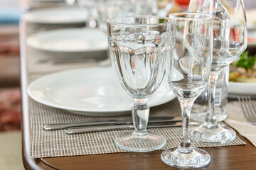 A table set with glasses and plates. A place at the table for a meal in a restaurant.