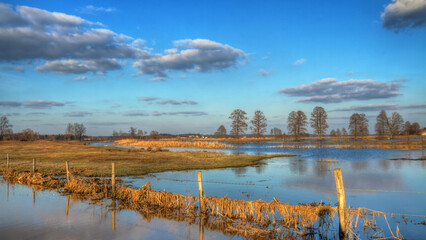 Landscape samazing blue sky with clouds valley river Narew Poland Europe spring time meadows under water backwards	