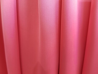 Wavy pink silk fabric in vertical folds (macro, texture).