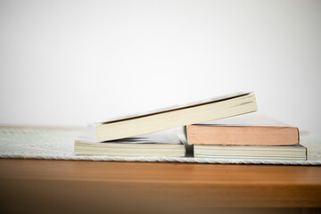 Books stack on wood desk and blurred background in the library room, education background, back to school concept. Image of education knowledge and study at school.