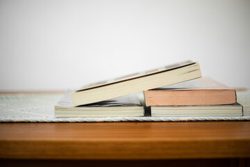 Books stack on wood desk and blurred background in the library room, education background, back to school concept. Image of education knowledge and study at school.