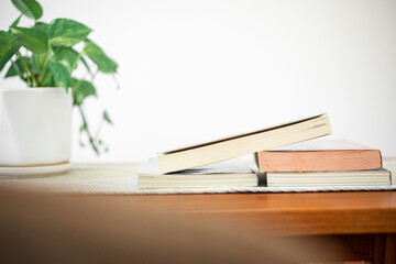 Books stack on wood desk and blurred background in the library room, education background, back to school concept. Image of education knowledge and study at school.