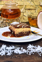 Coconut Cake on white plate with a spoon and caramel sauce
