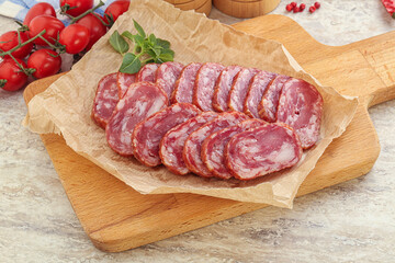 Sliced salami sausages over board