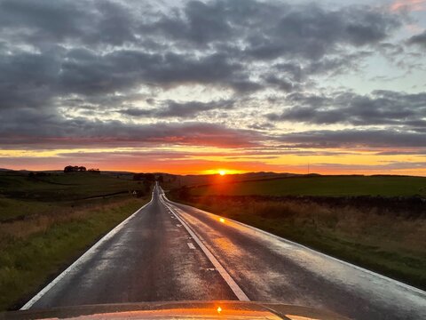 Sonnenuntergang auf langer gerader Stra&szlig;e