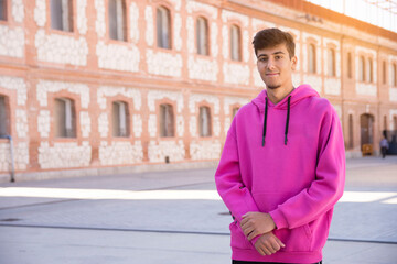 Handsome young man with pink sweater outside