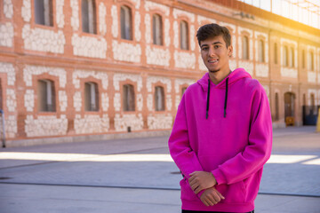 Handsome young man with pink sweater outside