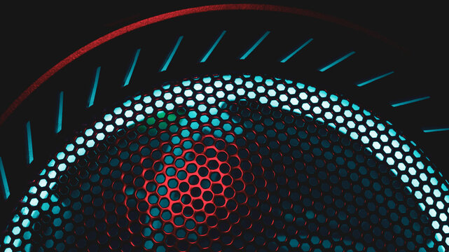 Colorful light of computer fan shines through the holes of protective grid. illumination glows in the dark. abstract futuristic background. led lighting of gaming pc