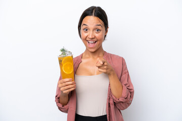 Young hispanic woman holding a cocktail isolated on white background surprised and pointing front
