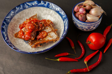 Tomato salted fish. Onions, tomatoes and chilies. black background.