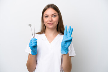 Dentist woman holding tools isolated on white background happy and counting three with fingers