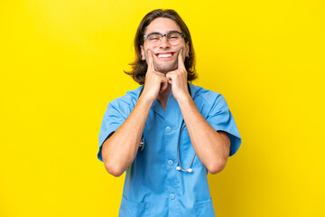 Young surgeon caucasian man isolated on yellow background smiling with a happy and pleasant expression