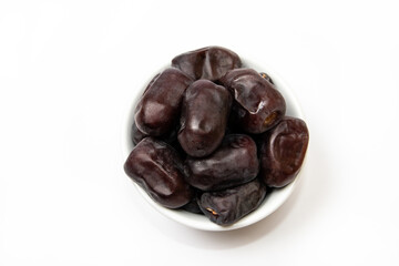 Fresh dates fruit in a white bowl on white background