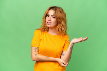 Young caucasian woman isolated on green screen chroma key background having doubts
