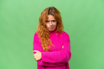 Young caucasian woman isolated on green screen chroma key background with unhappy expression