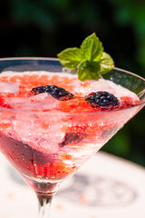 Eisgekühlter Molekular-Drink mit Beeren, Eiswürfeln und Minze