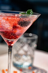 Eisgekühlter Molekular-Drink mit Beeren, Eiswürfeln und Minze